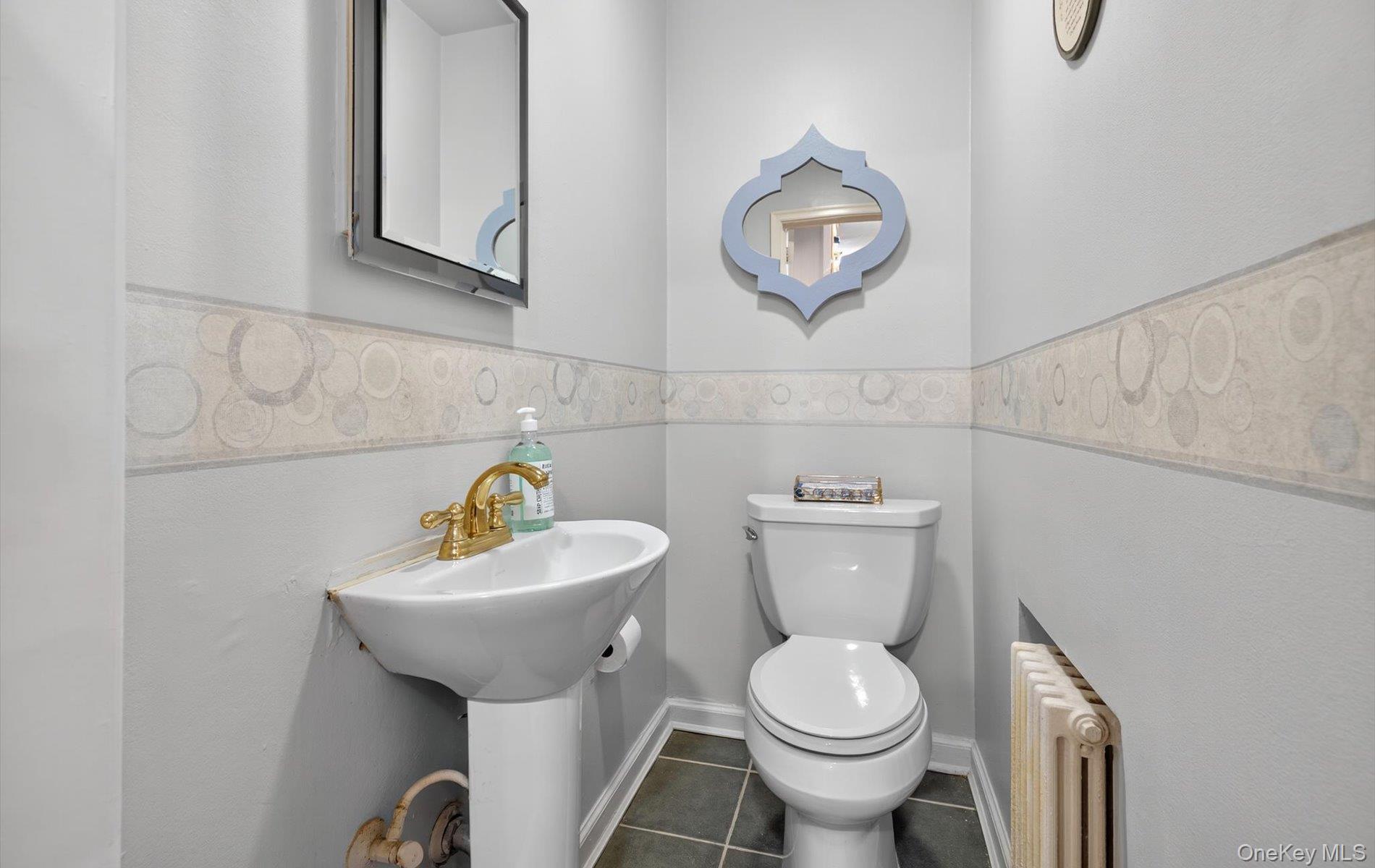 53 Eakins Road Manhasset, NY 11030 - Photo 18 of 34 a white toilet sitting next to a bathroom sink