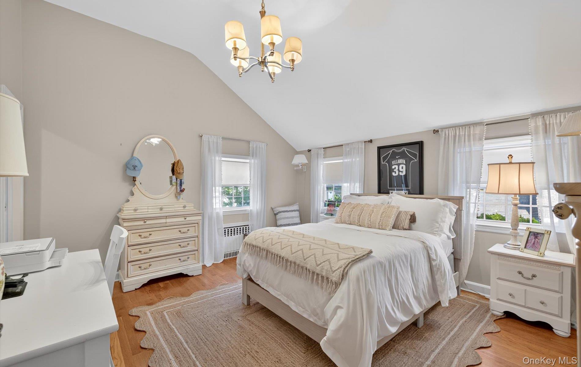 53 Eakins Road Manhasset, NY 11030 - Photo 23 of 34 a bedroom with a bed and a chandelier