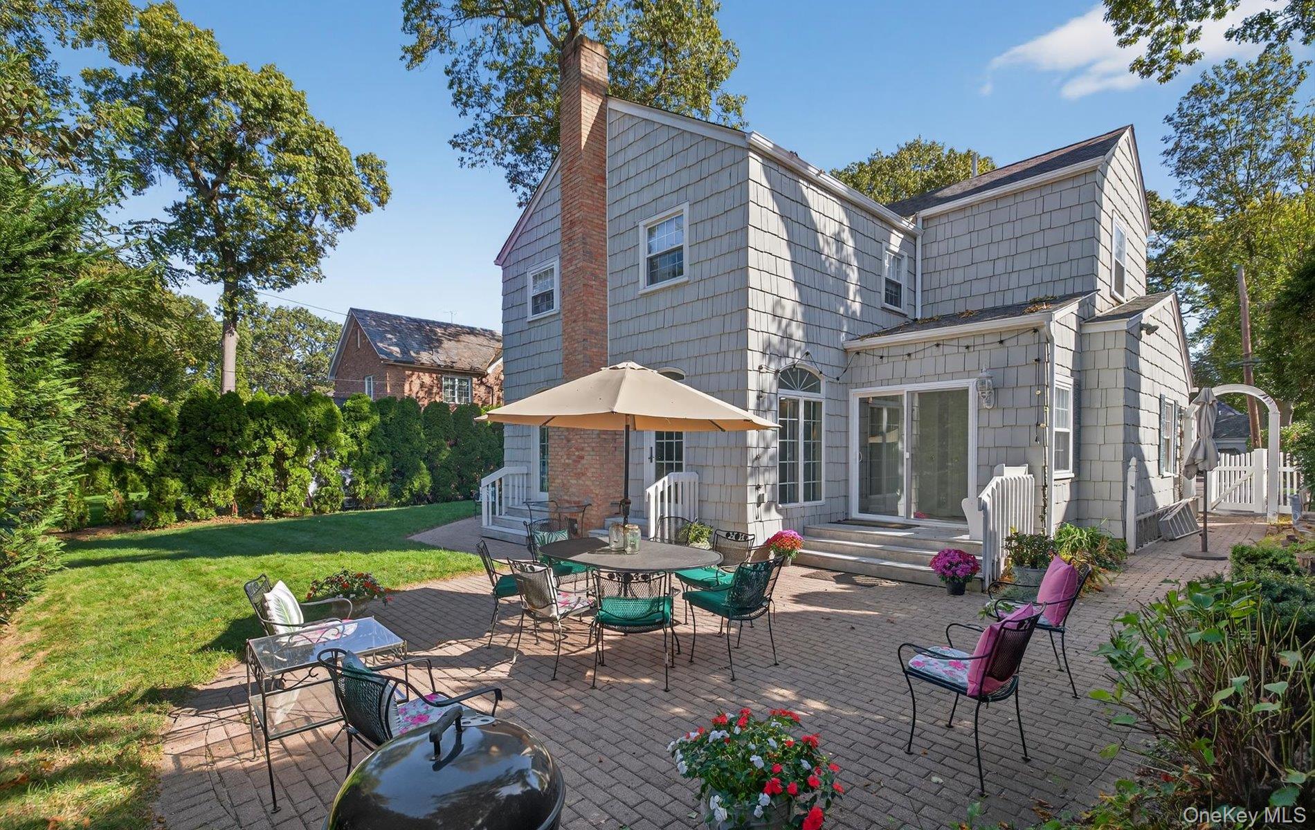 53 Eakins Road Manhasset, NY 11030 - Photo 31 of 34 a front view of a house with garden and sitting area