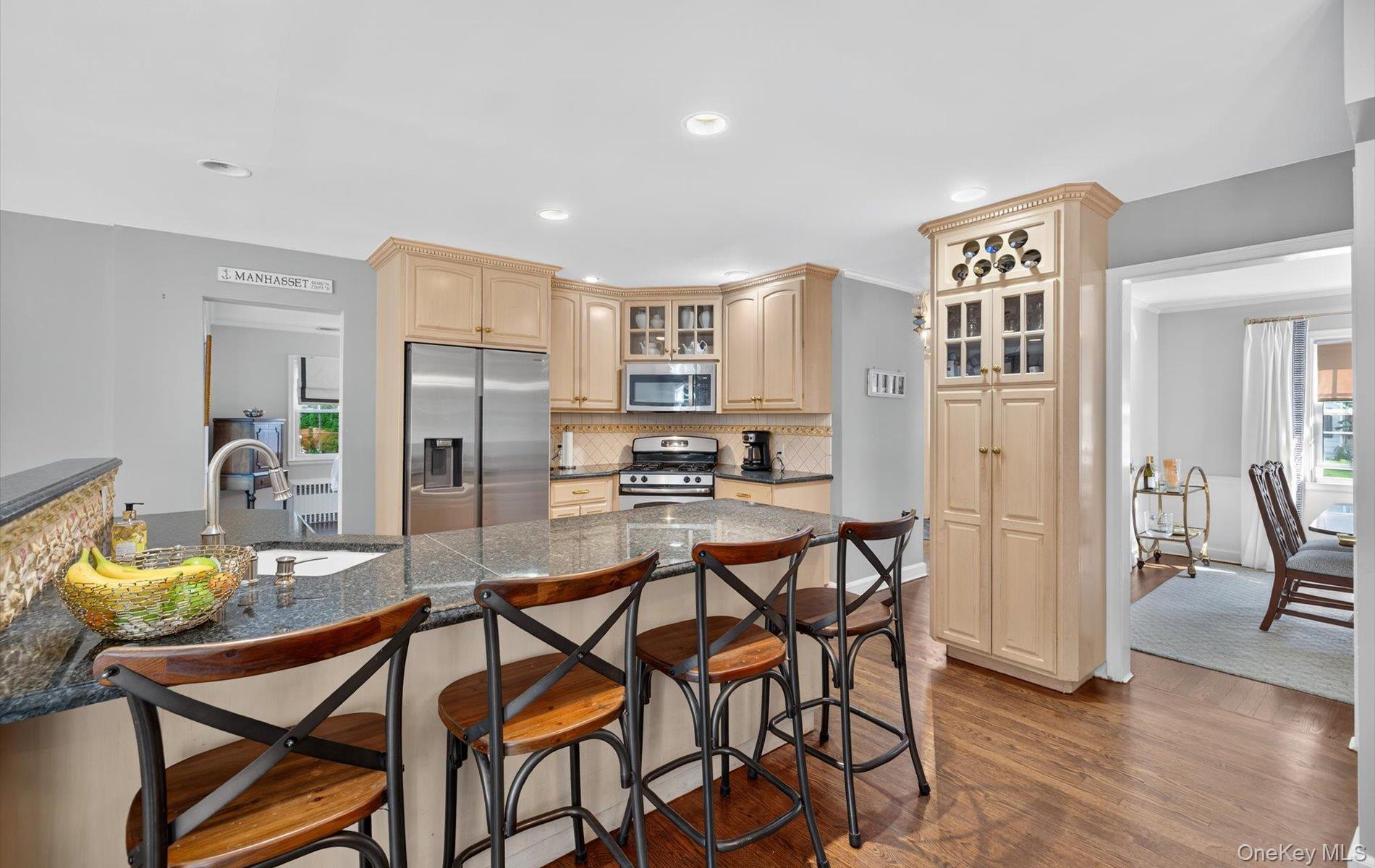 53 Eakins Road Manhasset, NY 11030 - Photo 10 of 34 a kitchen with stainless steel appliances kitchen island granite countertop a refrigerator and a stove top oven