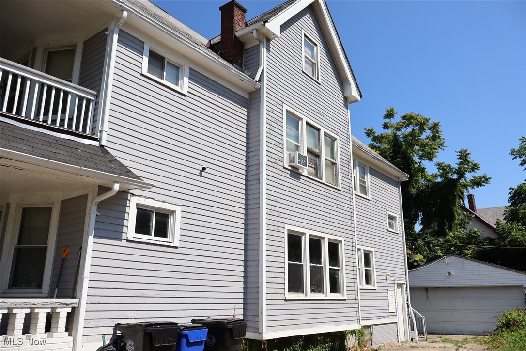 13519 Ashburton Road Cleveland, OH 44110 - Photo 3 of 12 View of property exterior featuring a chimney, an outdoor structure, and a balcony