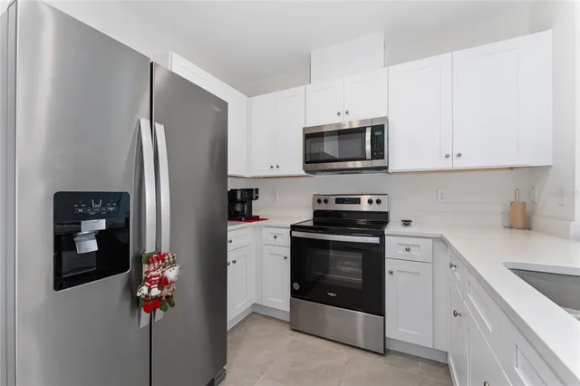 a kitchen with stainless steel appliances granite countertop white cabinets a refrigerator and a stove