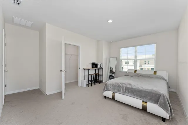 a spacious bedroom with a bed and a window