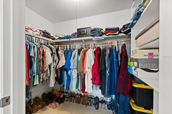 a view of walk in closet with clothes