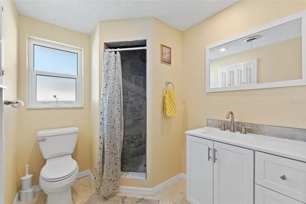 a bathroom with a granite countertop sink toilet and shower