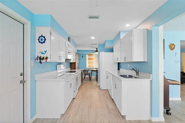 a large kitchen with a lot of counter space and wooden floor