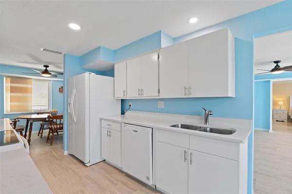 a kitchen with a sink a refrigerator and cabinets