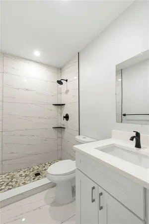 a bathroom with a sink a toilet and shower