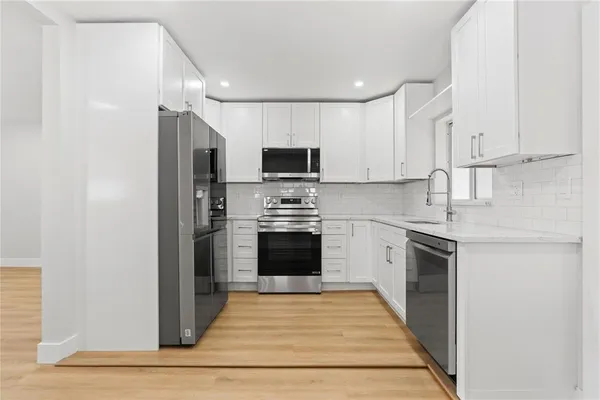 a kitchen with granite countertop a refrigerator stove and oven