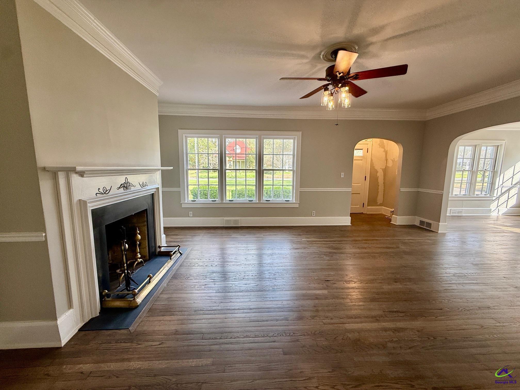 515 Engram Street Montezuma, GA 31063 - Photo 6 of 35 a view of an empty room with wooden floor fireplace and a window