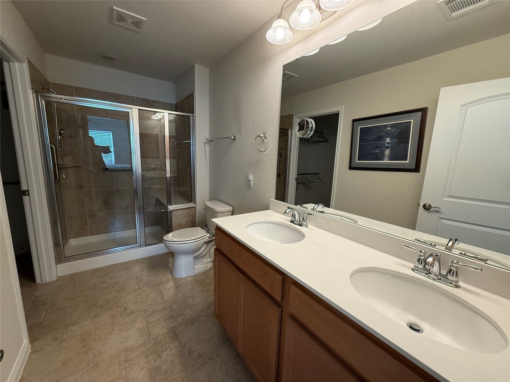 233 Hobby Street Georgetown, TX 78633 - Photo 7 of 13 a bathroom with a double vanity sink toilet and shower
