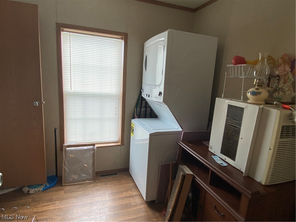 85 Rains Circle Zanesville, OH 43701 - Photo 15 of 15 Clothes washing area featuring stacked washer and clothes dryer, ornamental molding, plenty of natural light, and wood-type flooring Could also be used as 3rd bedroom