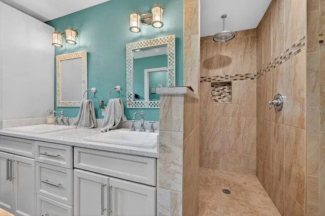 a bathroom with a sink vanity granite shower and a mirror