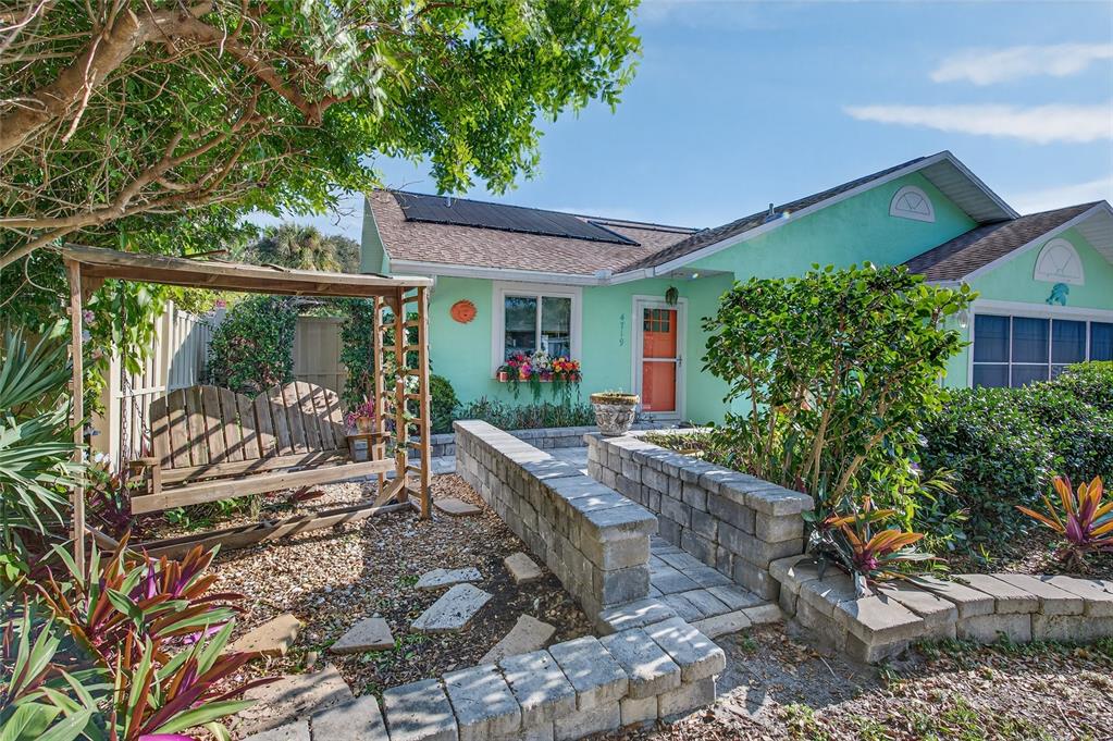 4719 Dixie Drive Ponce Inlet, FL 32127 - Photo 2 of 20 a view of a patio with table and chairs potted plants with large tree