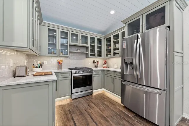 a kitchen with stainless steel appliances granite countertop a refrigerator sink and stove