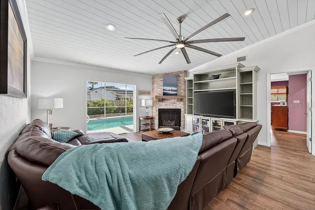 a living room with furniture a flat screen tv and a fireplace