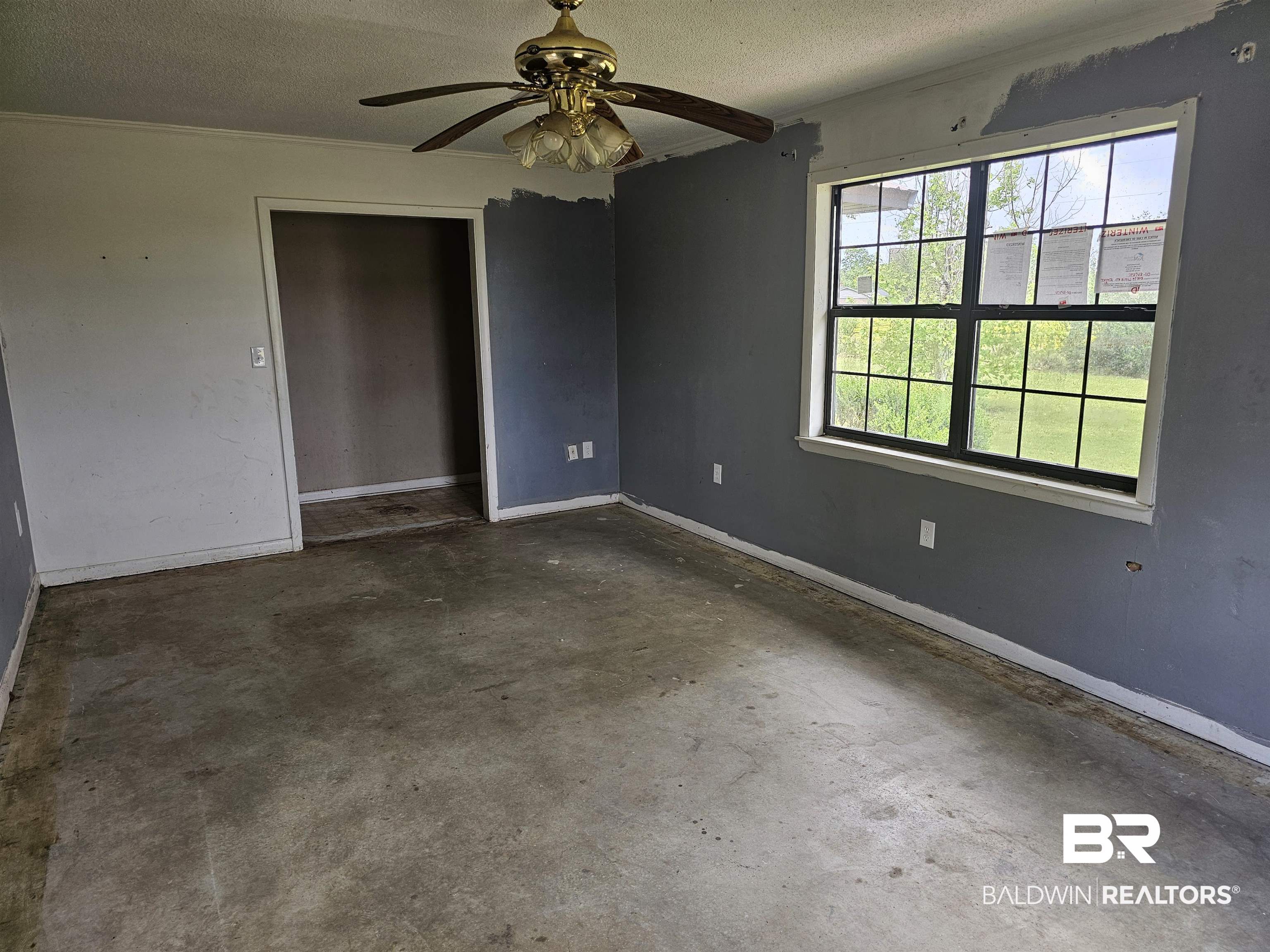 59575 Lottie Road Atmore, AL 36502 - Photo 11 of 23 Spare room featuring baseboards, concrete flooring, ceiling fan, and a textured ceiling