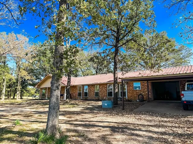a front view of a house with a tree