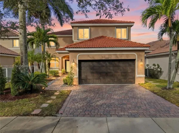 a front view of a house with a yard and a garage