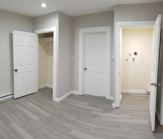 an empty room with wooden floor and closet area