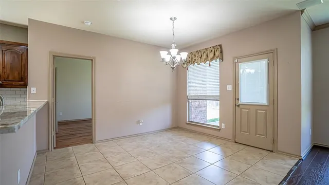 a view of an empty room with window and bathroom