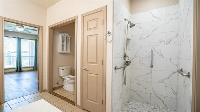 a bathroom with a granite countertop shower and a toilet