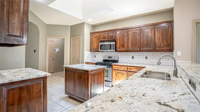 a kitchen with stainless steel appliances granite countertop a stove sink and cabinets