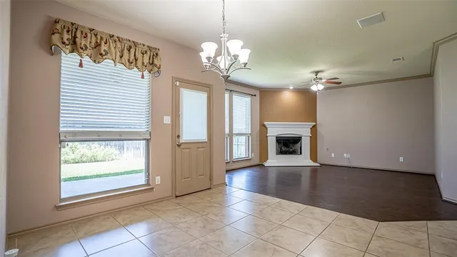a view of a livingroom with a chandelier fireplace and a window