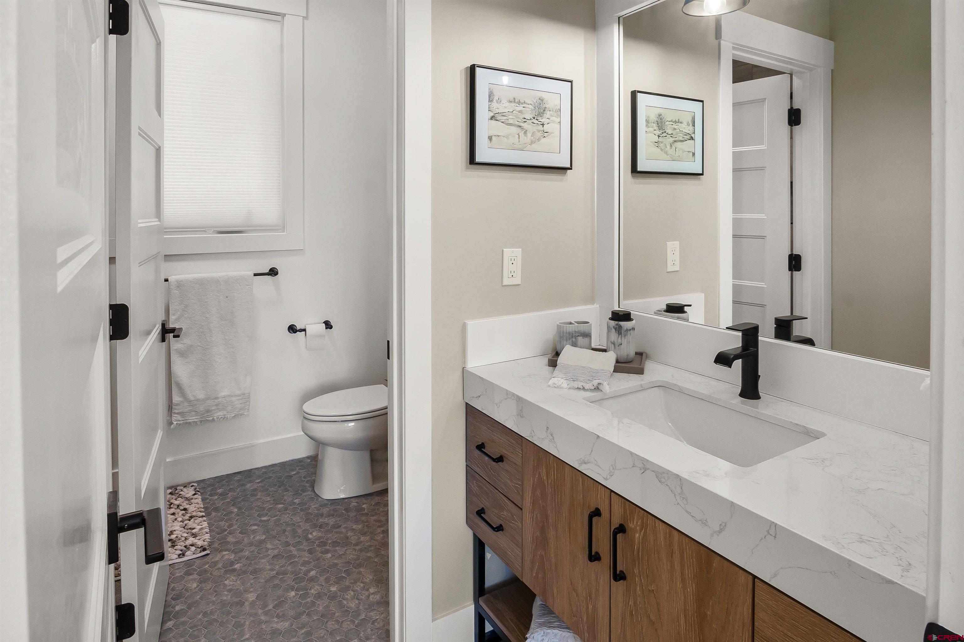 17 St Andrews Circle Durango, CO 81301 - Photo 18 of 28 a bathroom with a granite countertop sink a toilet and a mirror