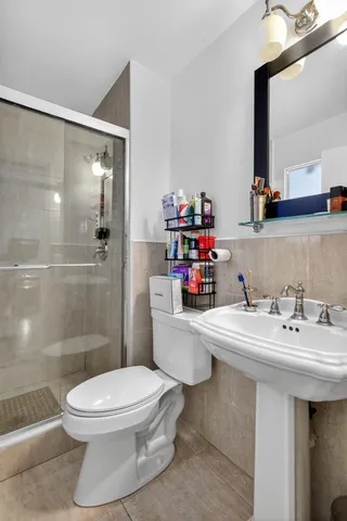 a bathroom with a sink a toilet and shower