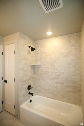 635 East Mountain Road North Ogden, UT 84414 - Photo 21 of 33 White bathtub with matte black fixtures and a stacked stone-look tile surround
