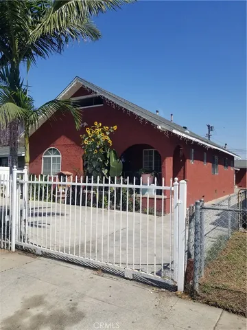 a view of a house with a small yard and wooden fence