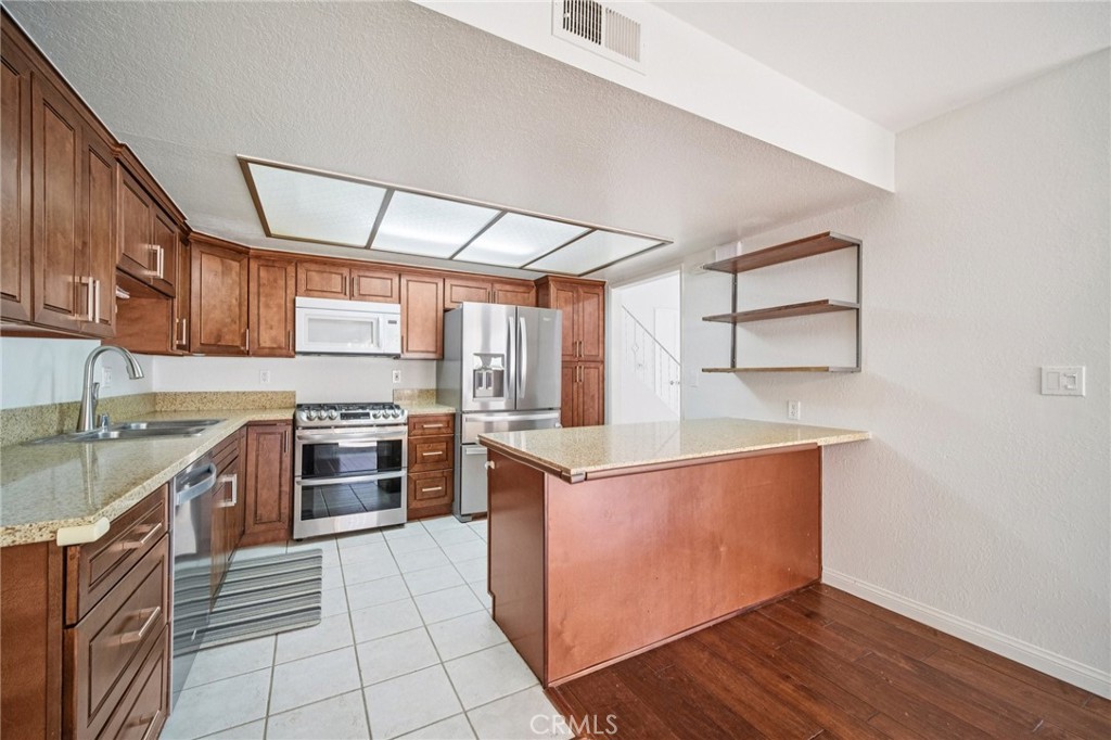 22810 Rio Chico Drive Valencia, CA 91354 - Photo 6 of 60 a kitchen with stainless steel appliances granite countertop a stove a sink and a refrigerator