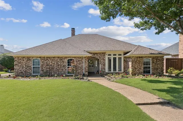 a front view of a house with a garden and patio