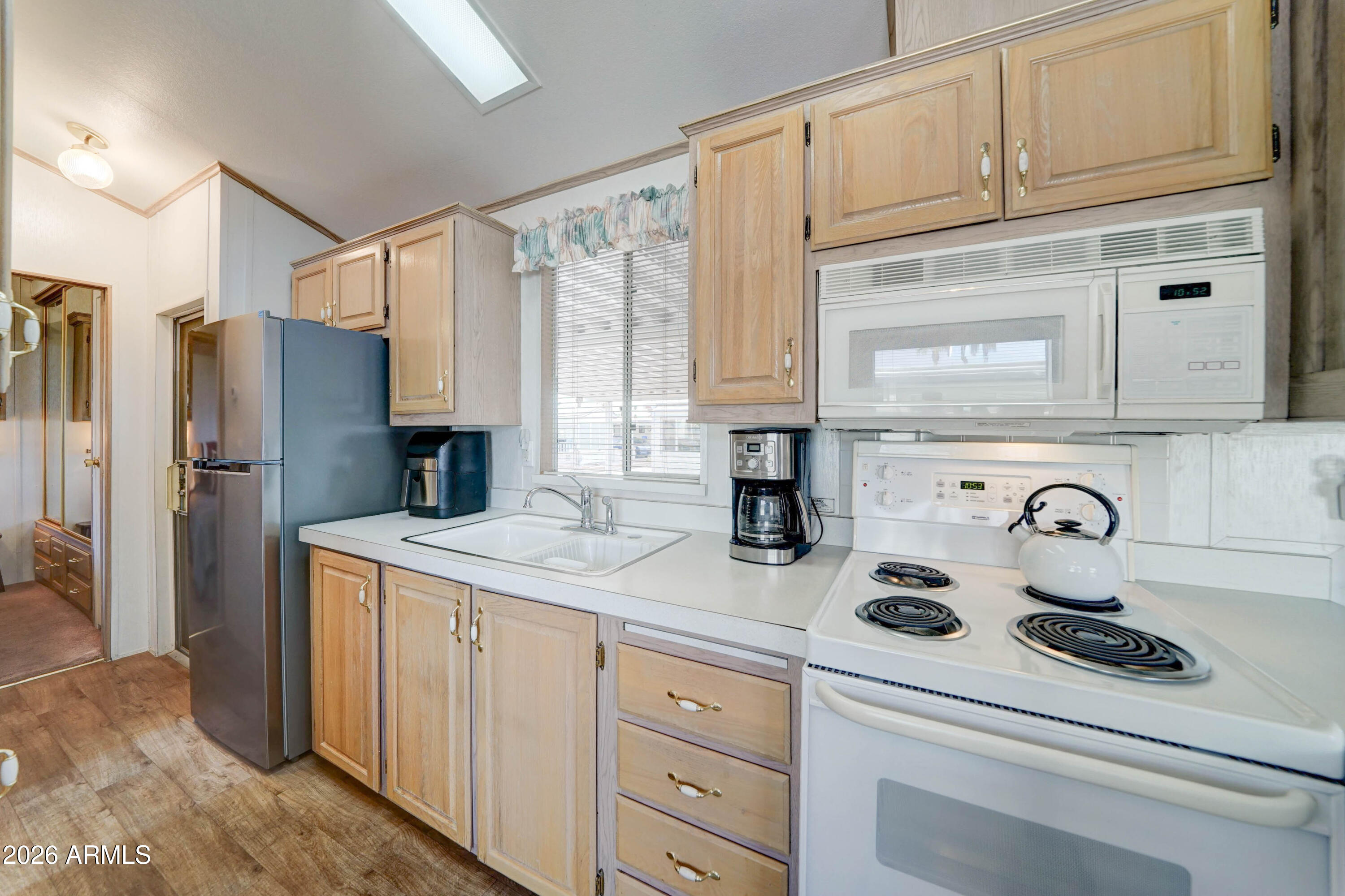 111 South Greenfield Road, Unit 520 Mesa, AZ 85206 - Photo 5 of 28 a kitchen with white cabinets and refrigerator