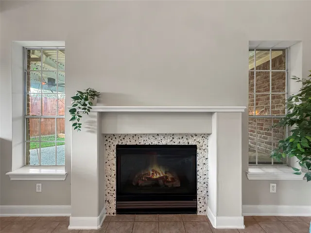 a living room with a fireplace and a potted plant