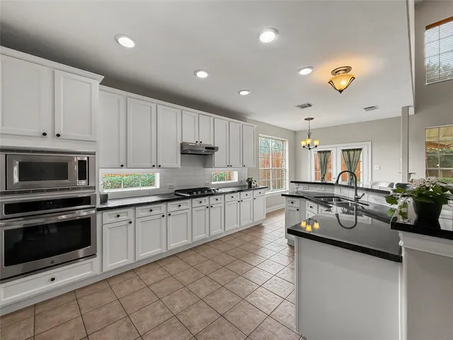 a kitchen with counter top space cabinets and stainless steel appliances