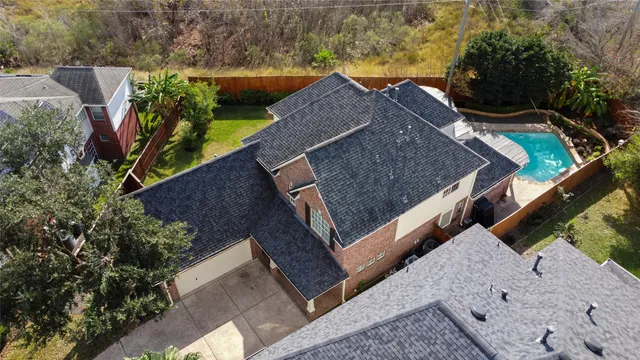 an aerial view of house with yard and swimming pool