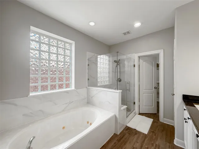 a view of empty room with wooden floor and a window