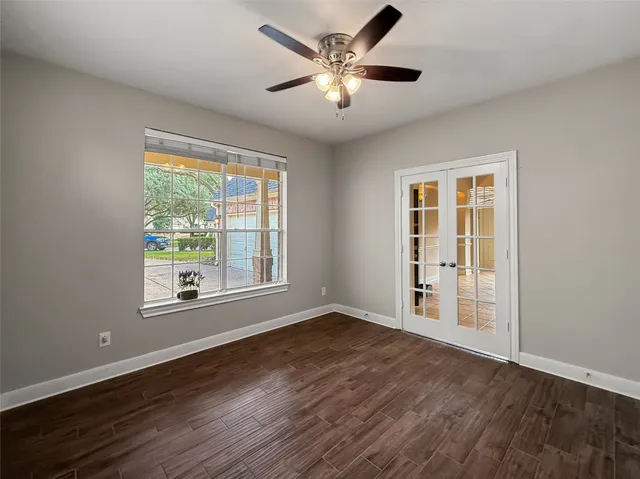 a view of an empty room with wooden floor and a window
