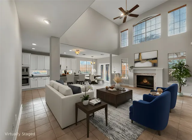a living room with furniture a fireplace and a ceiling fan