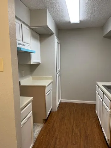 a kitchen with cabinets and wooden floor