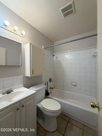 a bathroom with a toilet a sink a mirror and a bathtub