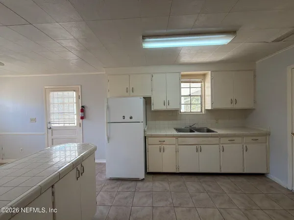 a kitchen with a sink a refrigerator and window