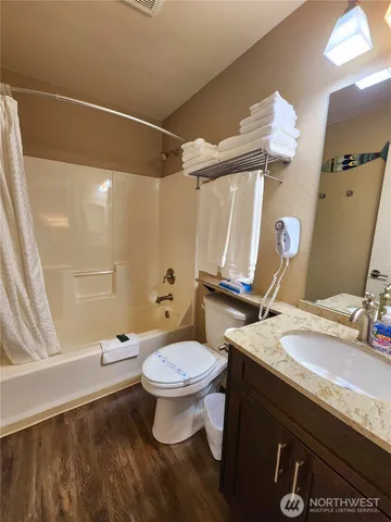 a bathroom with a sink a toilet a mirror and shower
