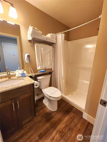 a bathroom with a granite countertop sink toilet a mirror and shower