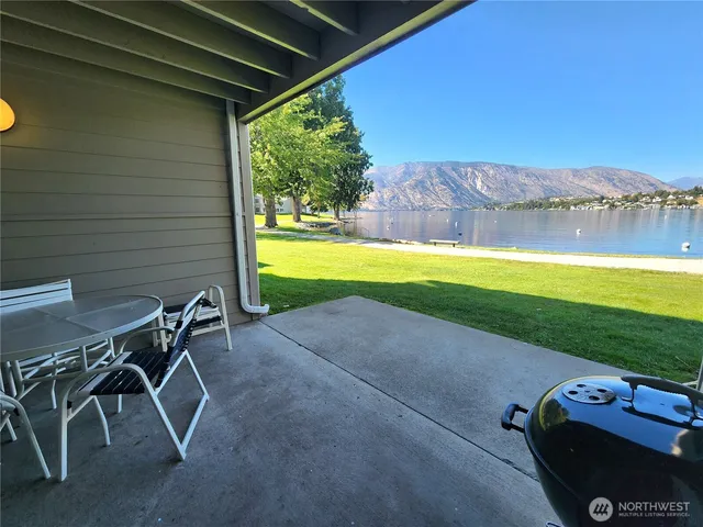 a view of a patio with table and chairs under an umbrella