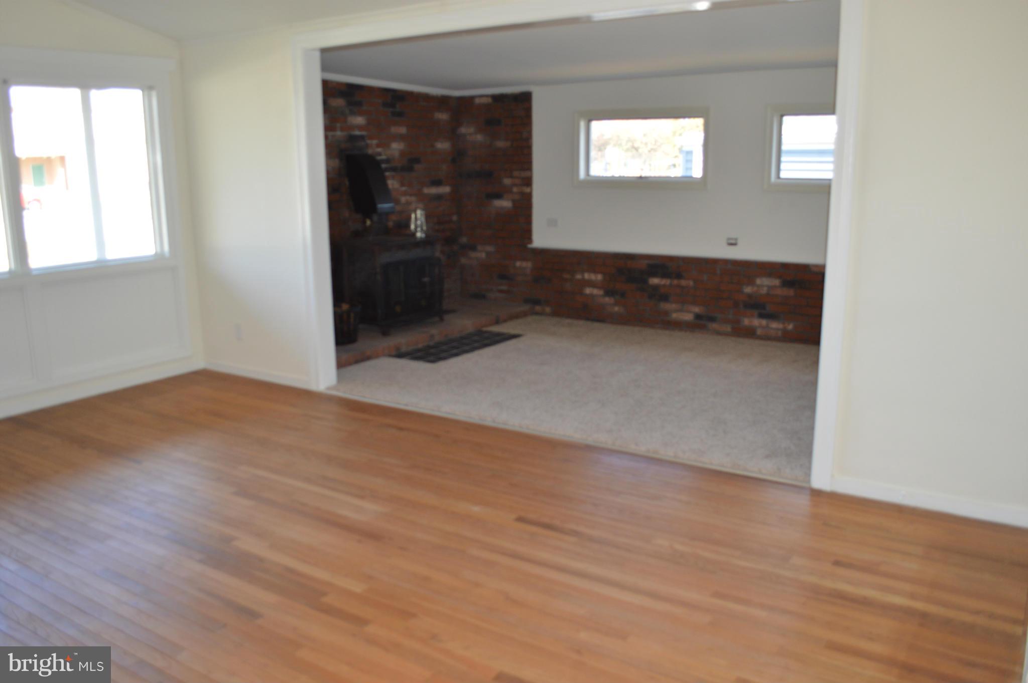 7605 Merritt Point Road Baltimore, MD 21222 - Photo 6 of 13 an empty room with wooden floor and windows