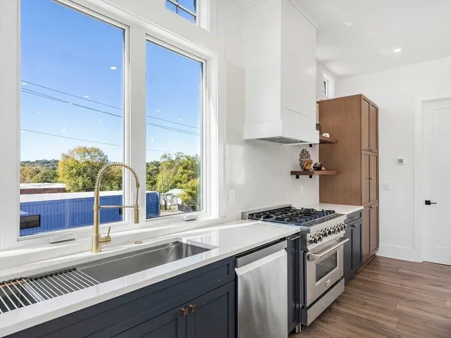 a kitchen with stainless steel appliances granite countertop a sink and a stove