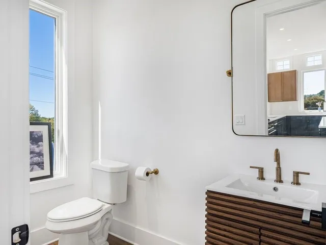 a bathroom with a sink a toilet and mirror